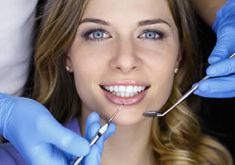 Frau beim Kontrolltermin mit zahnärztlichem Instrument im Mund